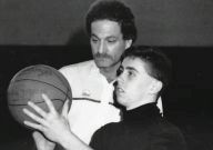 Buzz Braman, rear, works with a youth basketball player